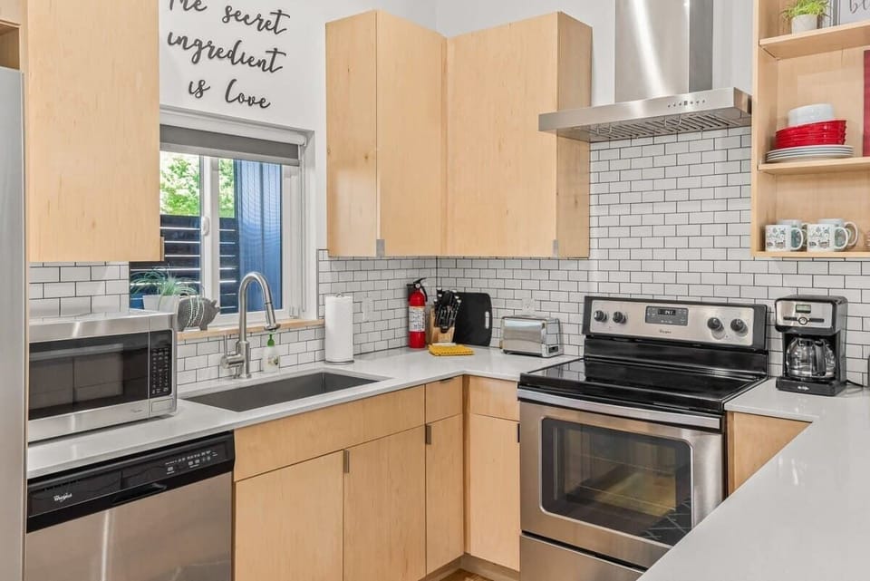 Modern kitchen with stainless appliances, granite countertops and stylish backsplash—cook at home or explore Fayetteville’s dining.