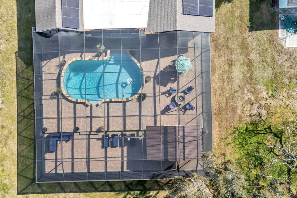 Overhead view showcasing the screened pool, spacious layout, and seamless flow from the home to the lake.
