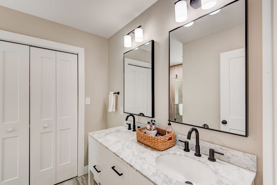 Double vanity with marble countertops and matte black fixtures. Plenty of room for everyone to get ready.