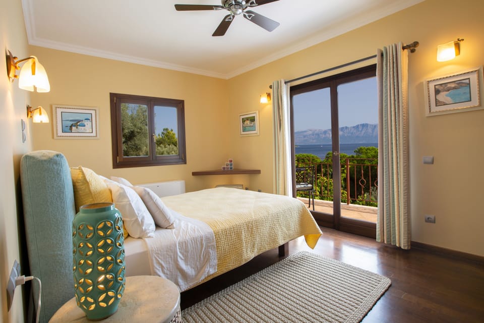 Second bedroom on top floor with private balcony seating.