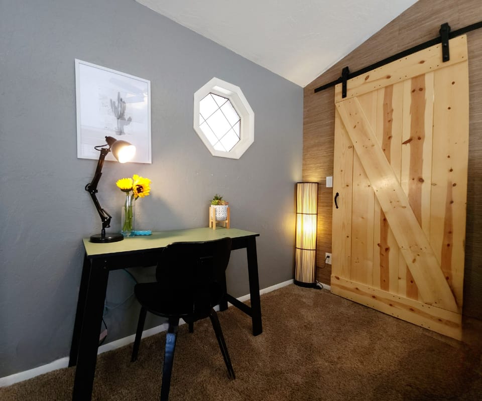 Mater bedroom features a dedicated work area with desk, lamp and power station