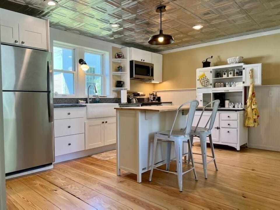 This new kitchen has a tin ceiling, coffee station and an island.