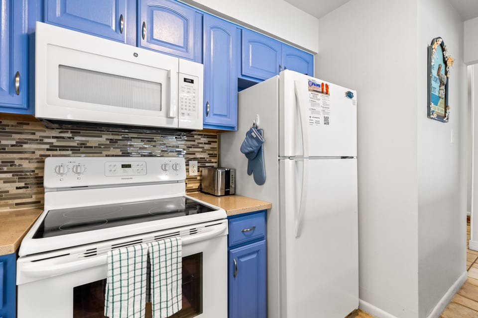 Your fully equipped kitchen features bright blue cabinets, modern appliances, and everything you need to prepare meals during your stay.
