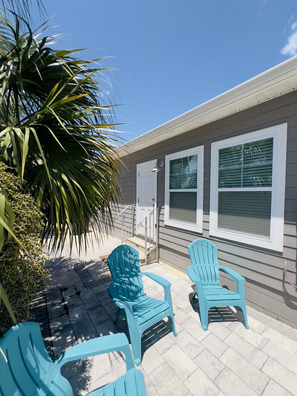 Side patio offers an outdoor shower, seating and a charcoal weber grill
