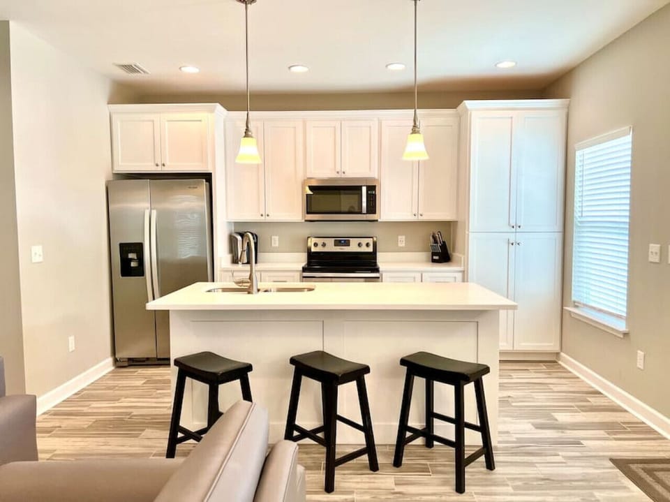 Kitchen with stainless steel appliances, quartz countertops and a breakfast bar