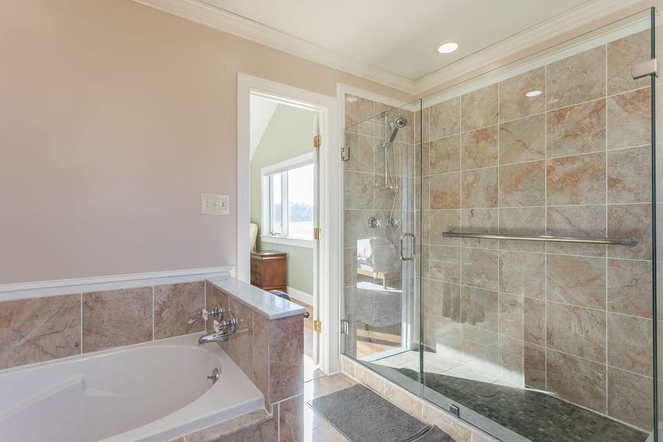 Master bath with soaking tub and large glass shower