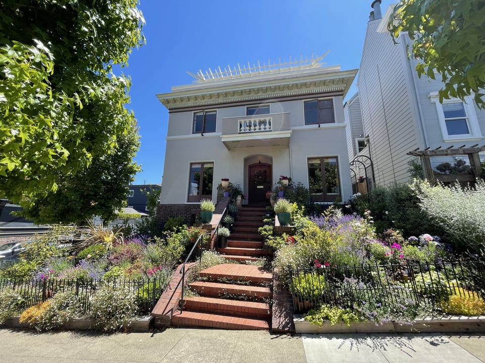 Corner house surrounded by a beautiful garden and picture perfect houses