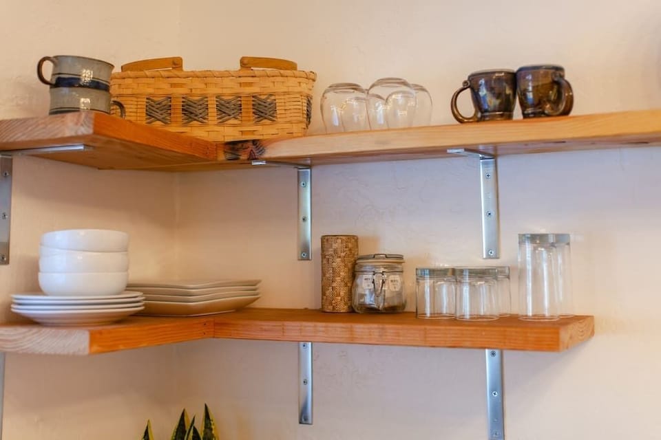 Open shelving with beautifully arranged dinnerware and kitchen basics.