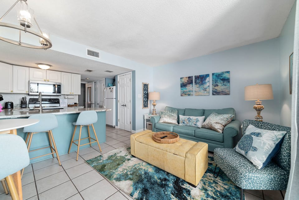 Coastal-inspired comfort meets modern style in this inviting living space. The open-concept layout seamlessly connects the kitchen and living room, creating the perfect flow for entertaining. Relax on the plush sofa and enjoy the tranquil, beachy vibes.