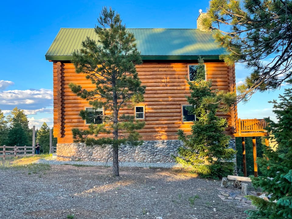 Cabin on top of the hill overlooking the trees.