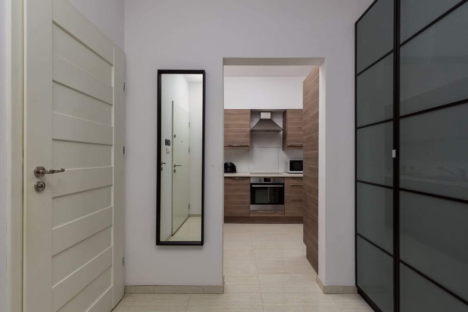 Hallway with a modern door, mirror, and sleek interior decor.
