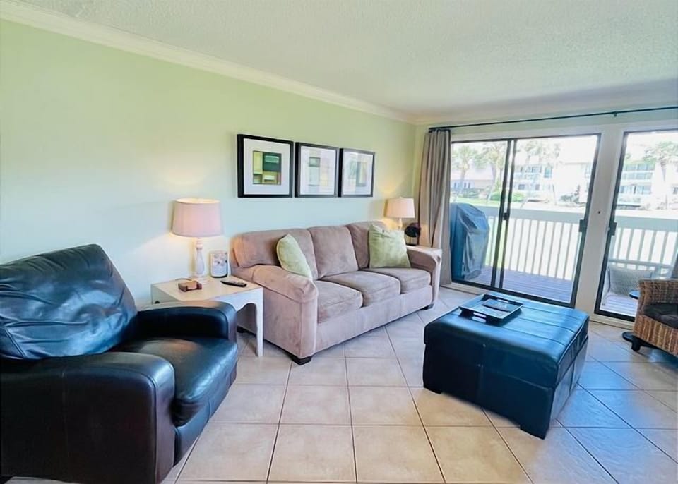 Unwind in your bright living space with cozy seating, where afternoon light filters through sliding doors to your private balcony.