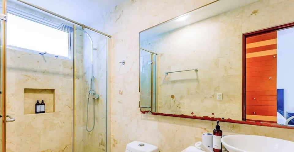 Modern bathroom featuring a glass-enclosed shower and a large mirror for a spacious feel