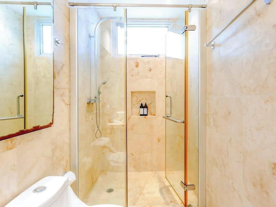 modern bathroom with glass-enclosed shower and marble walls