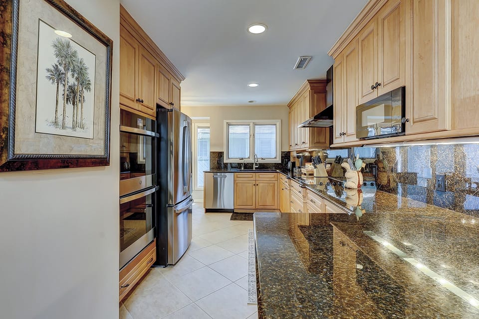 Fully stocked kitchen with 2 barstools for extra seating.