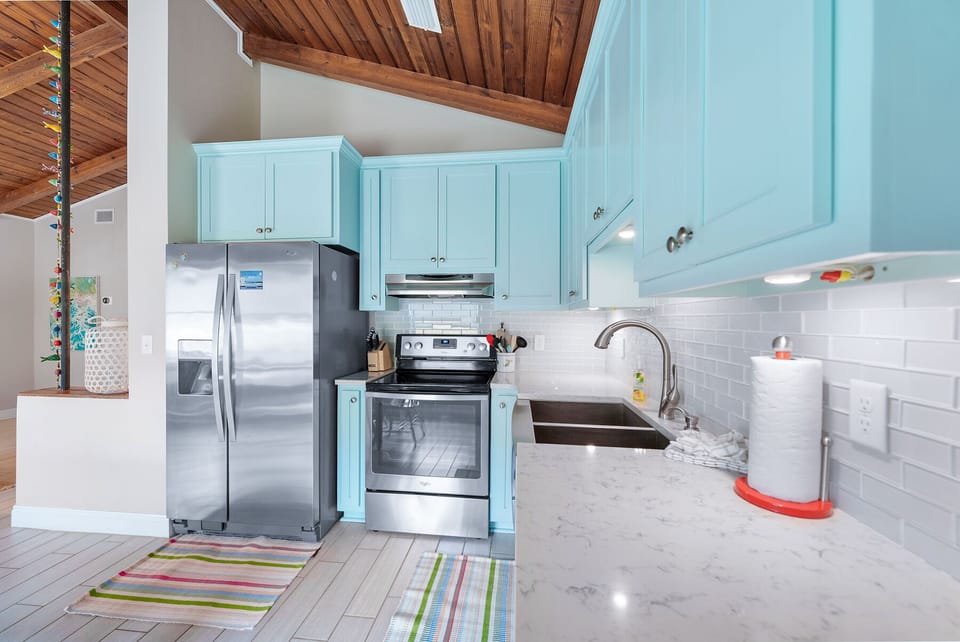 Your bright, fully-equipped kitchen invites you to cook with style beneath beautiful wood ceilings and turquoise cabinets.