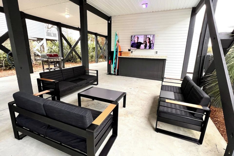 Outdoor lounge with a gas grill, SmartTV, and outdoor games.