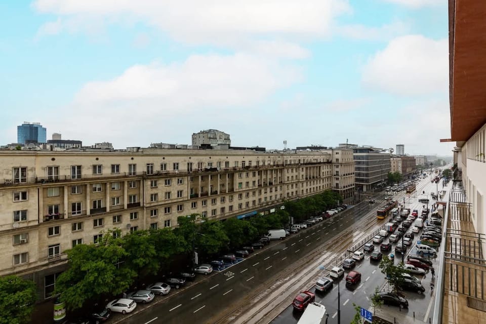 Cityscape showing a mix of old and new buildings with a wide view of the street below.
