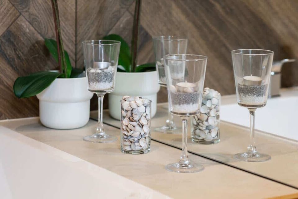 A set of glasses on a table, along with a decorative plant. This setup brings an elegant yet homey feel to the dining or living area.