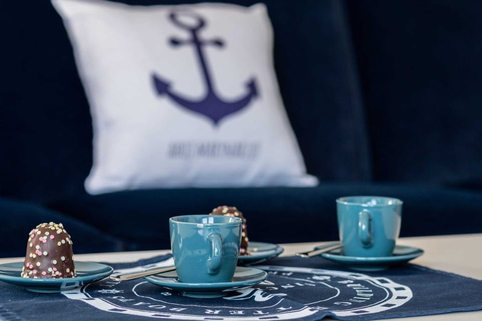 A close-up of a blue-themed coffee table set with decorative cups and matching coasters.
