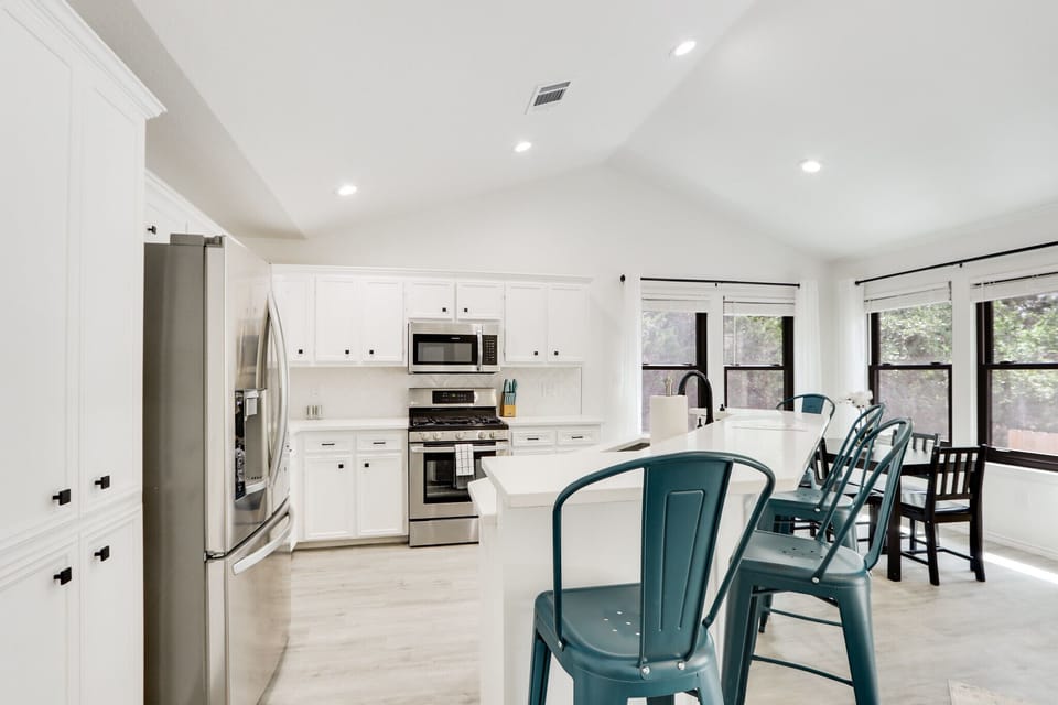 The kitchen is modern and open with stainless steel appliances