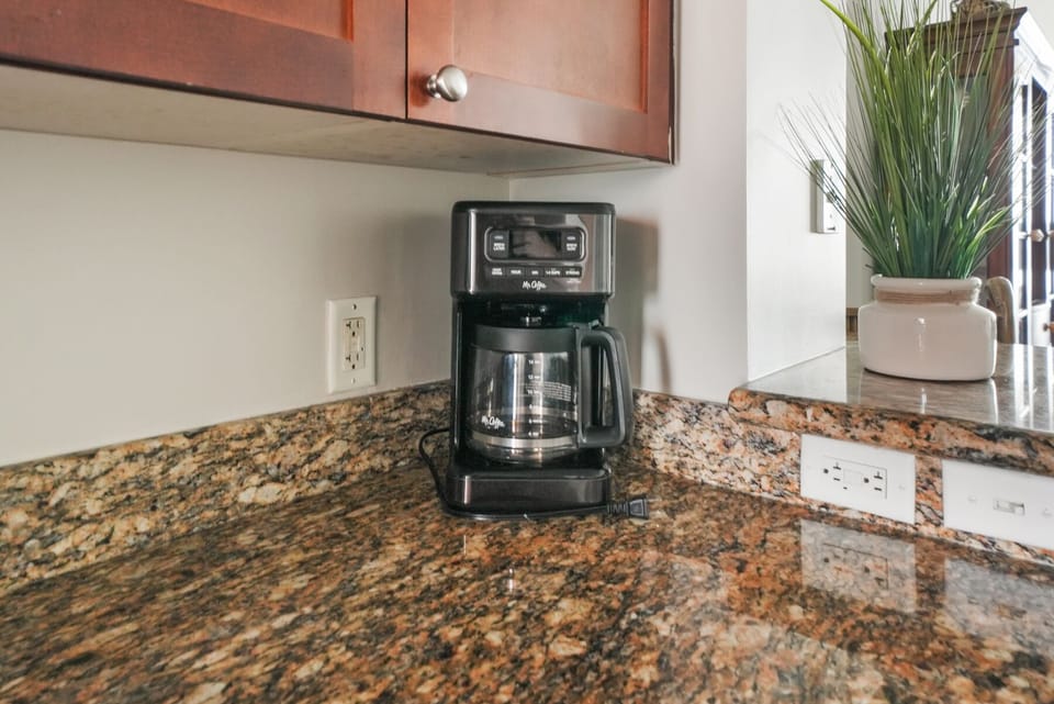 Start your mornings right with fresh coffee from your fully-equipped kitchen counter, complete with granite surfaces and modern appliances.