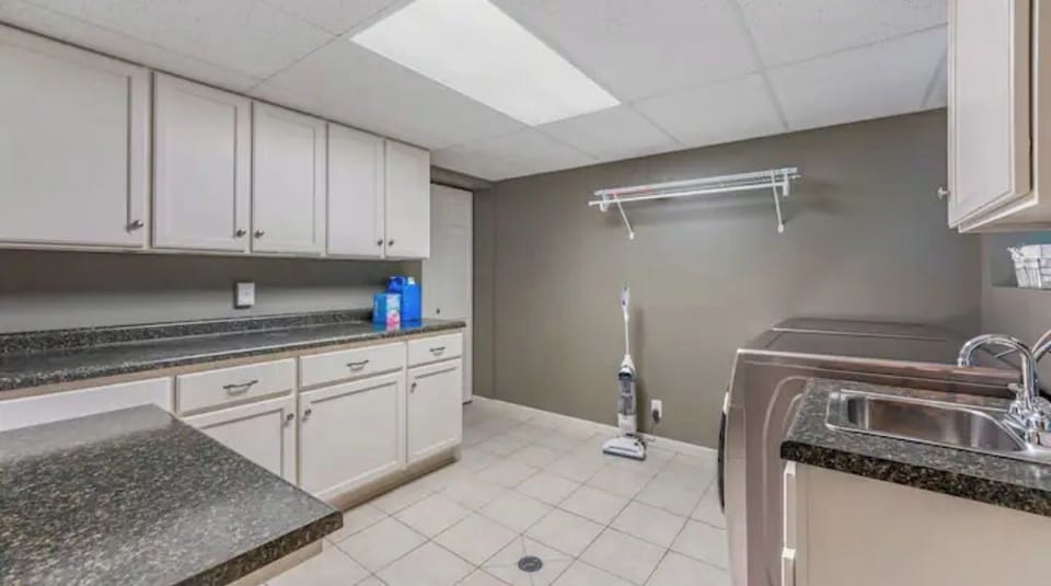 laundry room w/ washer, dryer, vacuum, small fridge