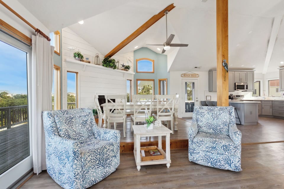 Relax in the beautiful Living Area with a Flat Screen TV, panoramic windows, and beach decor.