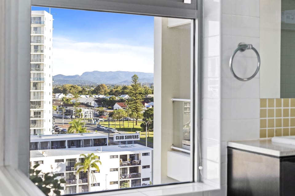 The picturesque city view with the mountains as the backdrop in the bathroom