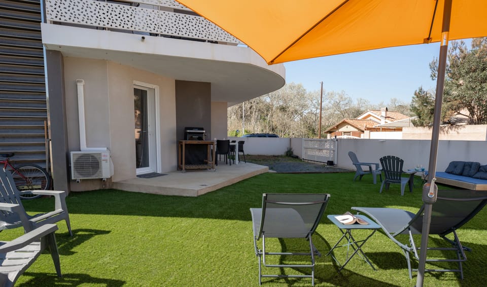 Large garden with sun loungers, lower lounge and dining area