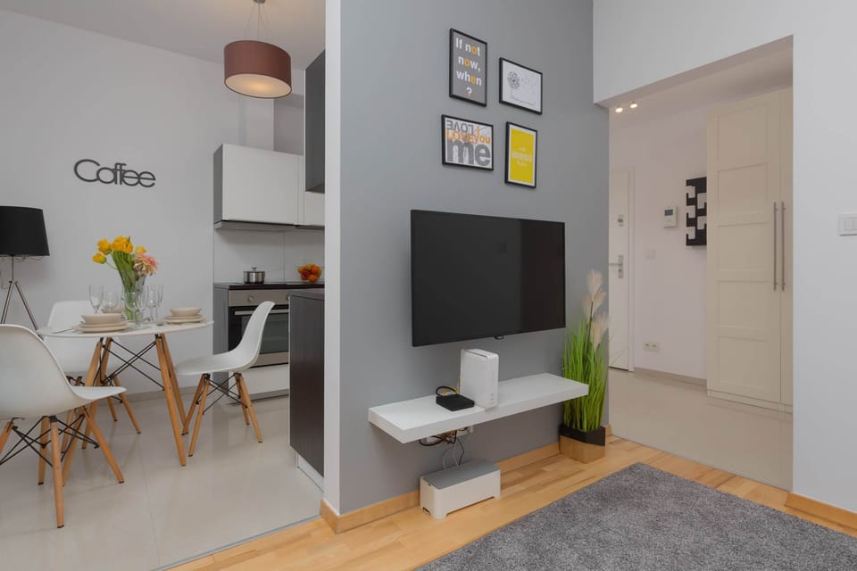 Living area corner with a TV, dining table, and cozy seating space in a modern design.
