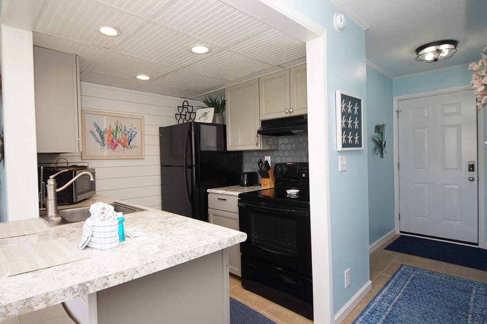 Whip up your favorite meals in this bright, fully-equipped kitchen with granite countertops, stainless steel appliances, and coastal charm throughout.