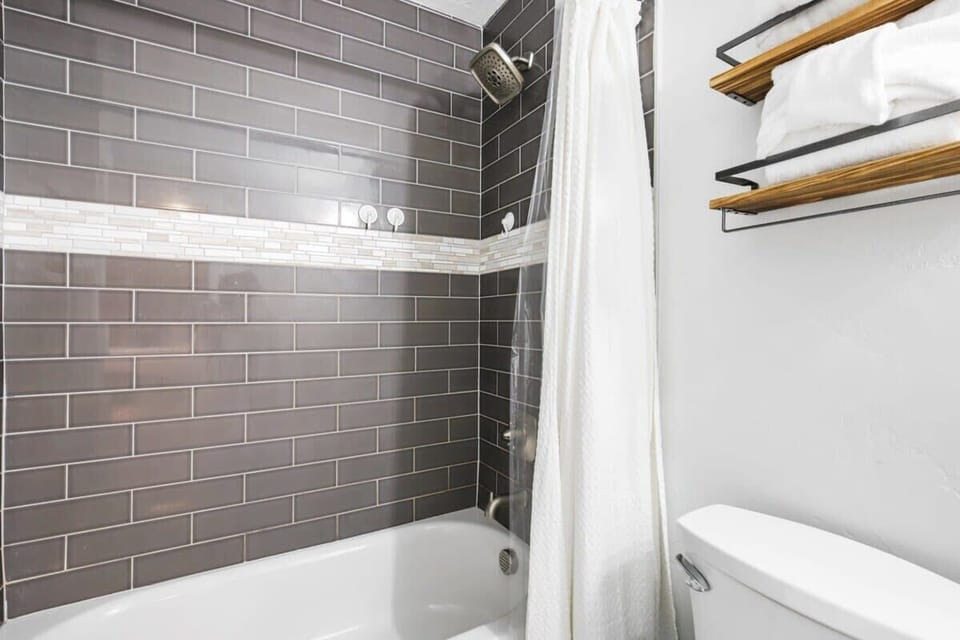 The fabulous shower/tub combo in the master bathroom features striking tile work.