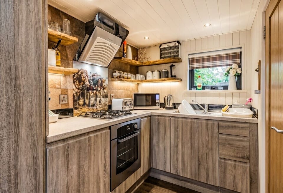 The compact kitchen has gas hob, oven, microwave and fridge for easy cooking.