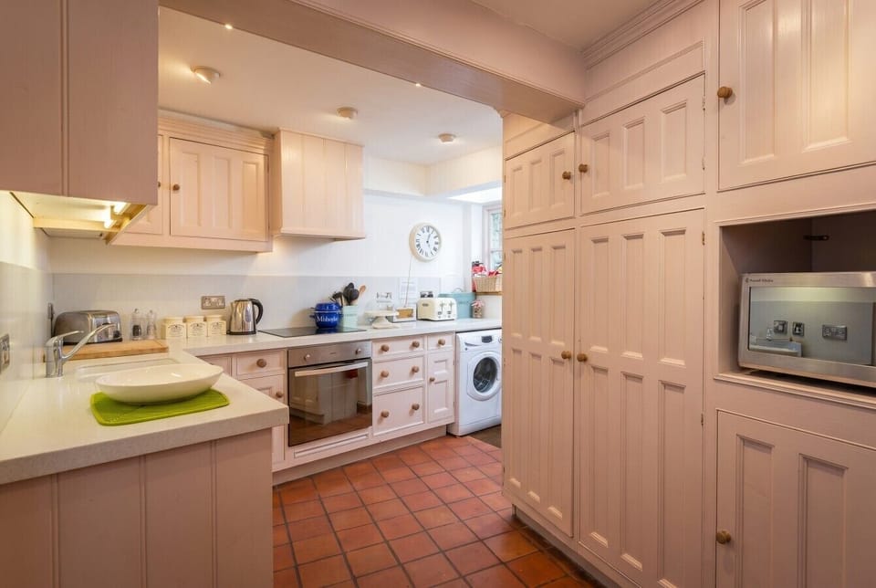 Full kitchen with washing machine and pantry storage