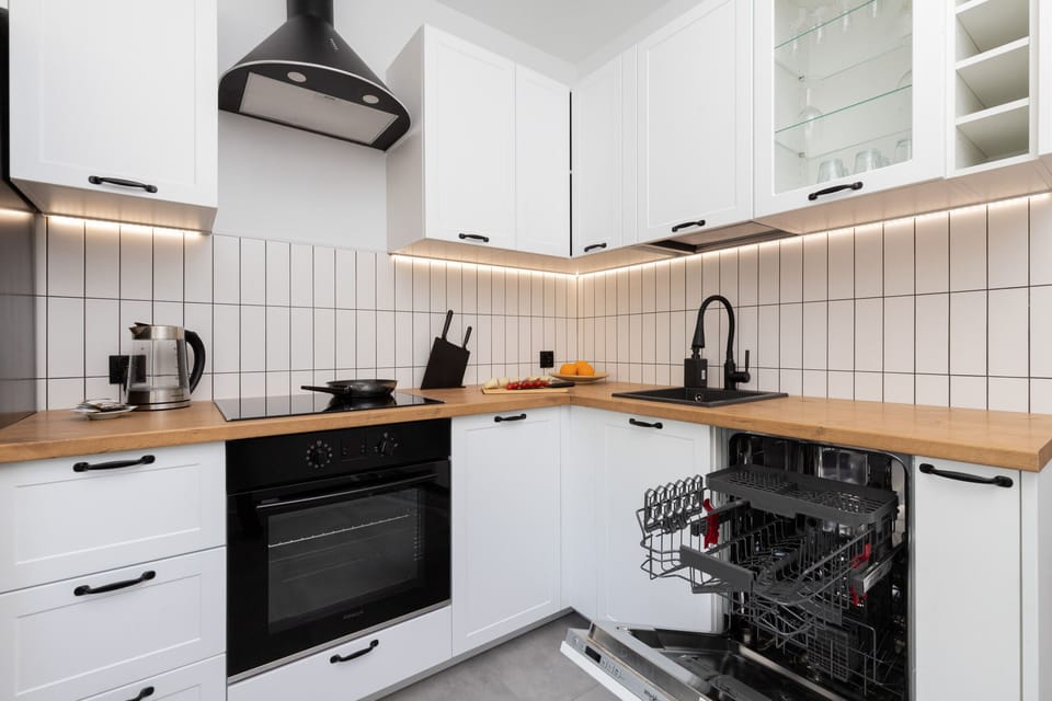 Kitchen corner with built-in oven, stylish backsplash, and a cozy functional layout.
