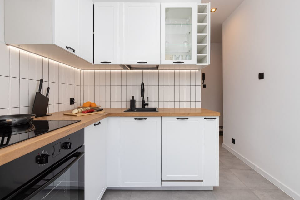 Another angle of the kitchen showcasing clean finishes, modern appliances, and bright lighting.
