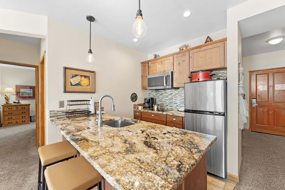 Your fully equipped kitchen features granite countertops, stainless appliances, and warm wood cabinets perfect for preparing meals together.