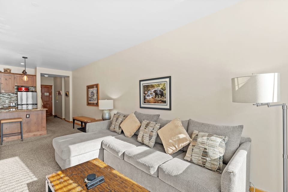 Relax on your plush sectional sofa with cozy pillows while enjoying the open layout connecting to your fully equipped kitchen.