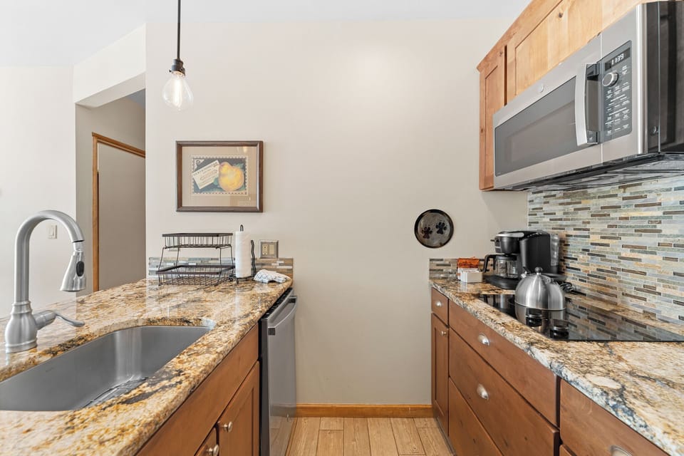 Your fully equipped kitchen features granite counters, coffee maker, and modern appliances for preparing memorable meals during your stay.