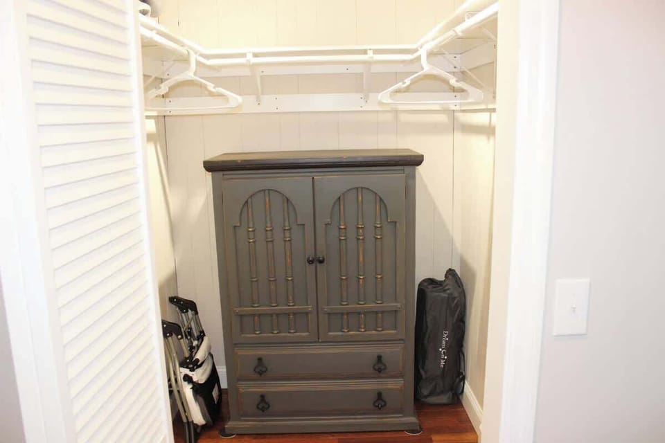 Master bedroom walk-in closet with hangers, dresser, pack and play and high chair (see next picture for the high chair and pack and play).