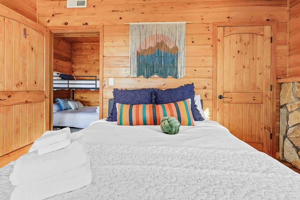 Recharge + Reset. Crisp fresh white linens throughout the cabin. Guest bedroom includes cozy queen memory foam mattress with direct access to lower Spa deck and long range Smokey Mountain Views right from your room.