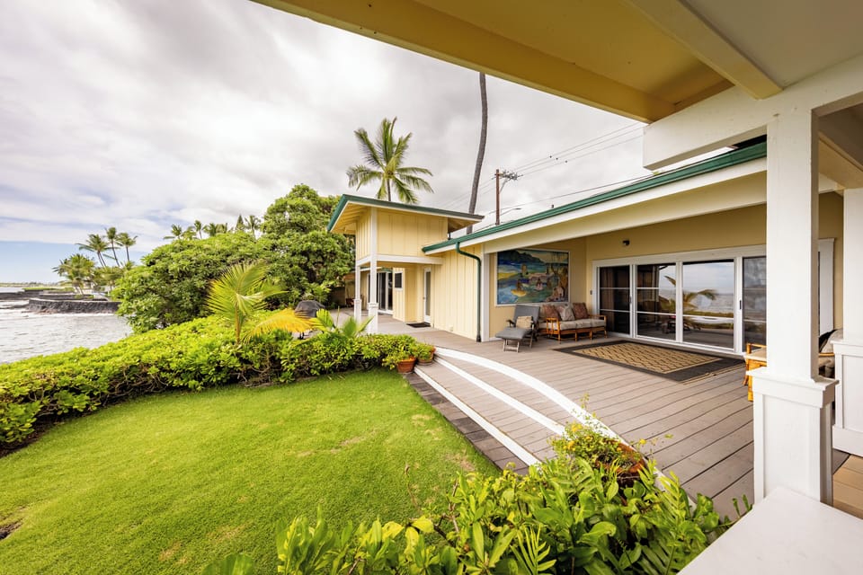 Spacious covered lanai with lush green lawn and tropical landscaping