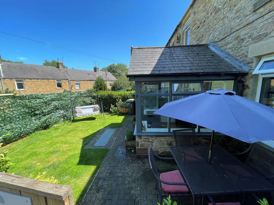 Front garden with swing seat and dining area.
