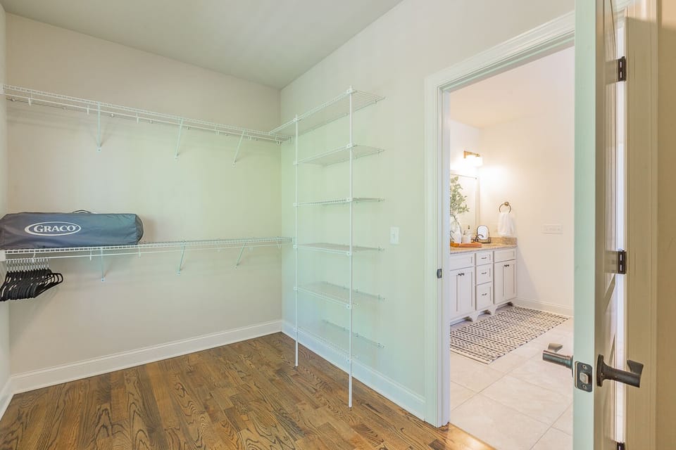 Master bedroom closet with iron, ironing board, pack-n-play and high chair