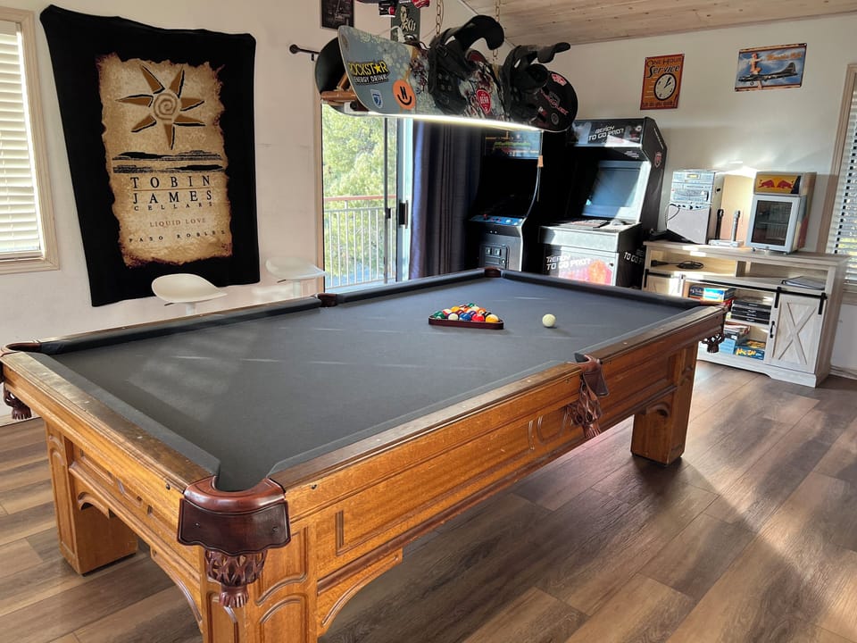 Professional size 9 ft pool table is the centerpiece of the game room.