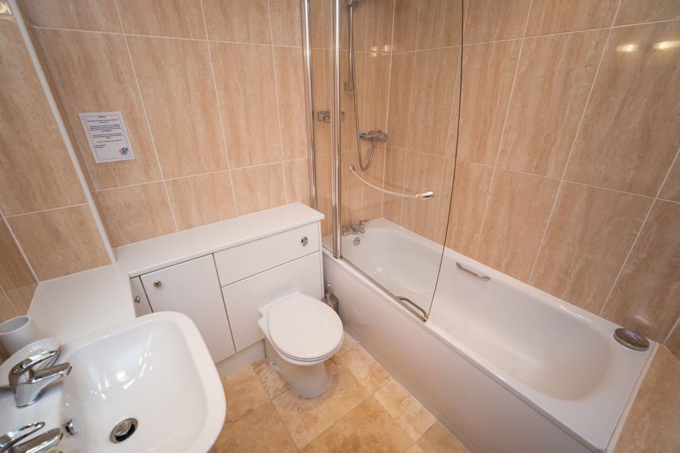 The family bathroom benefits from a bath and overhead shower
