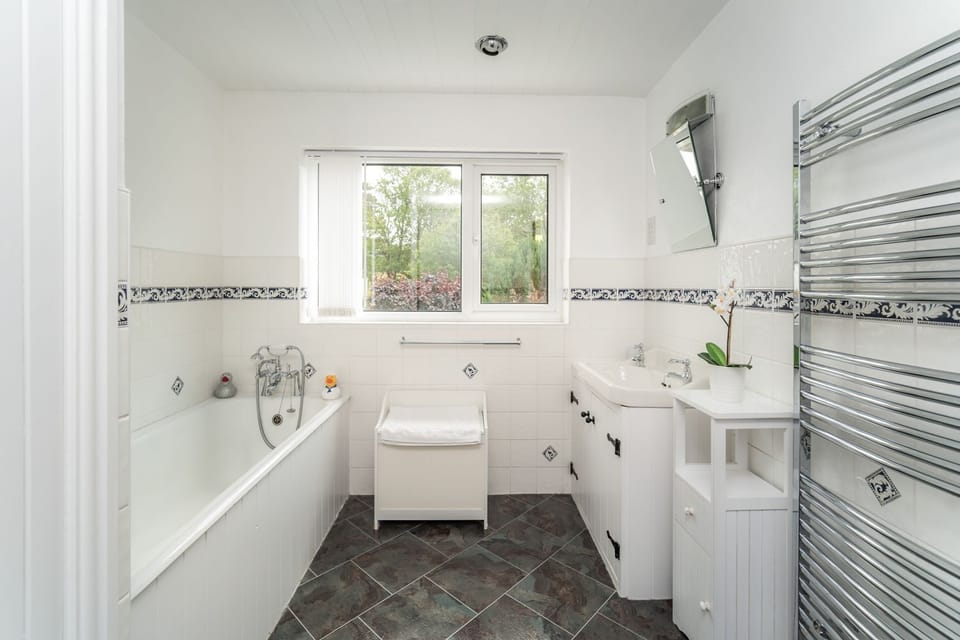 The bathroom comprises bath and separate walk in shower, sink and heated towel rail