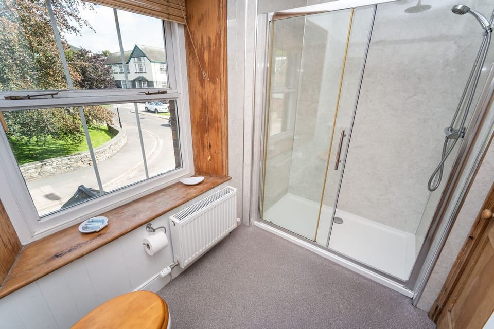 The delightful wood panelled washroom has a large walk in shower
