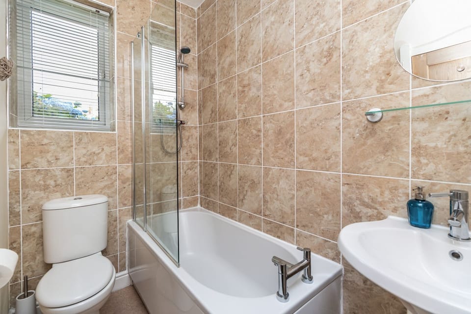 The family bathroom has a bath with overhead shower